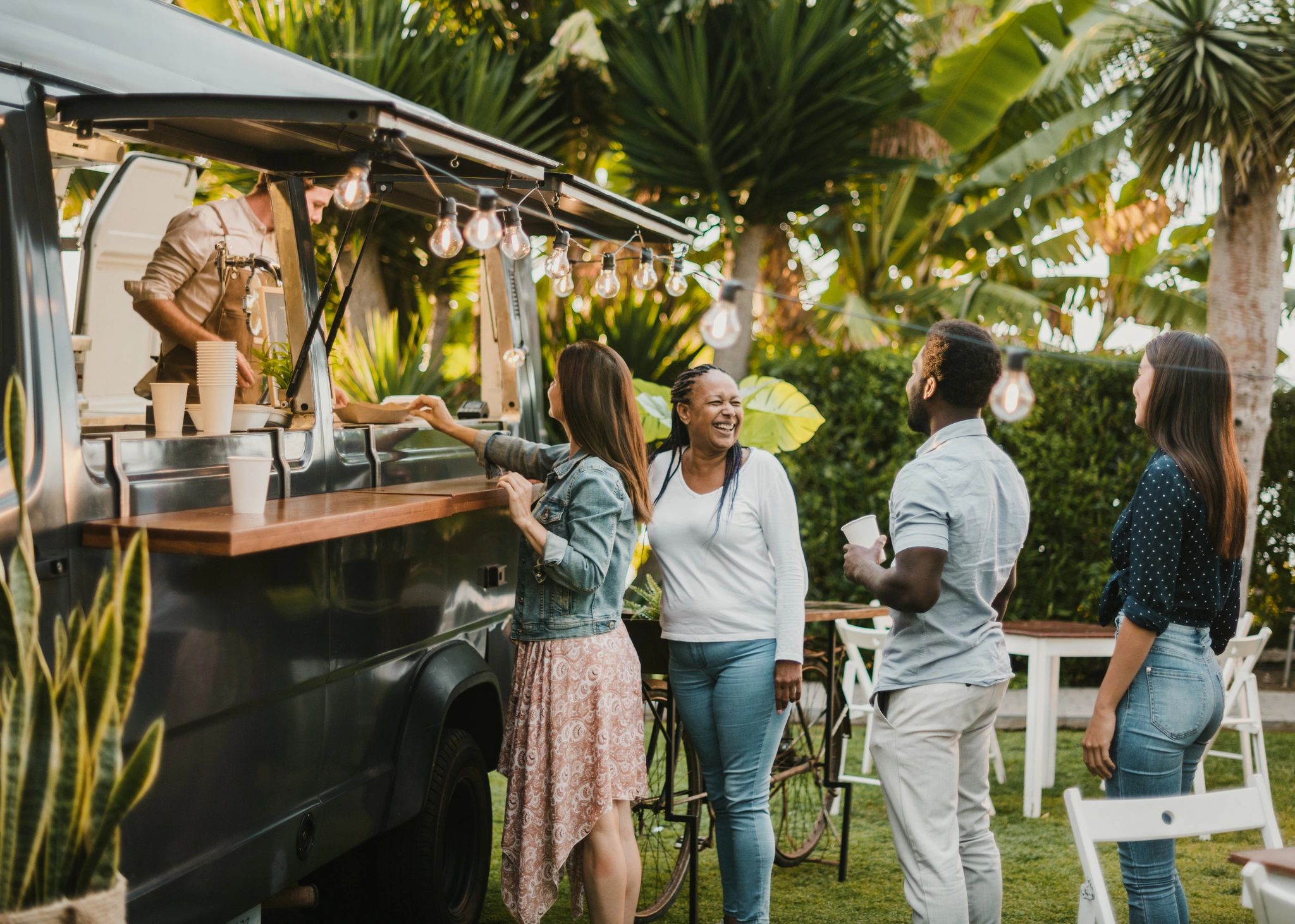 Guests chatting in line at an outdoor mobile coffee setup