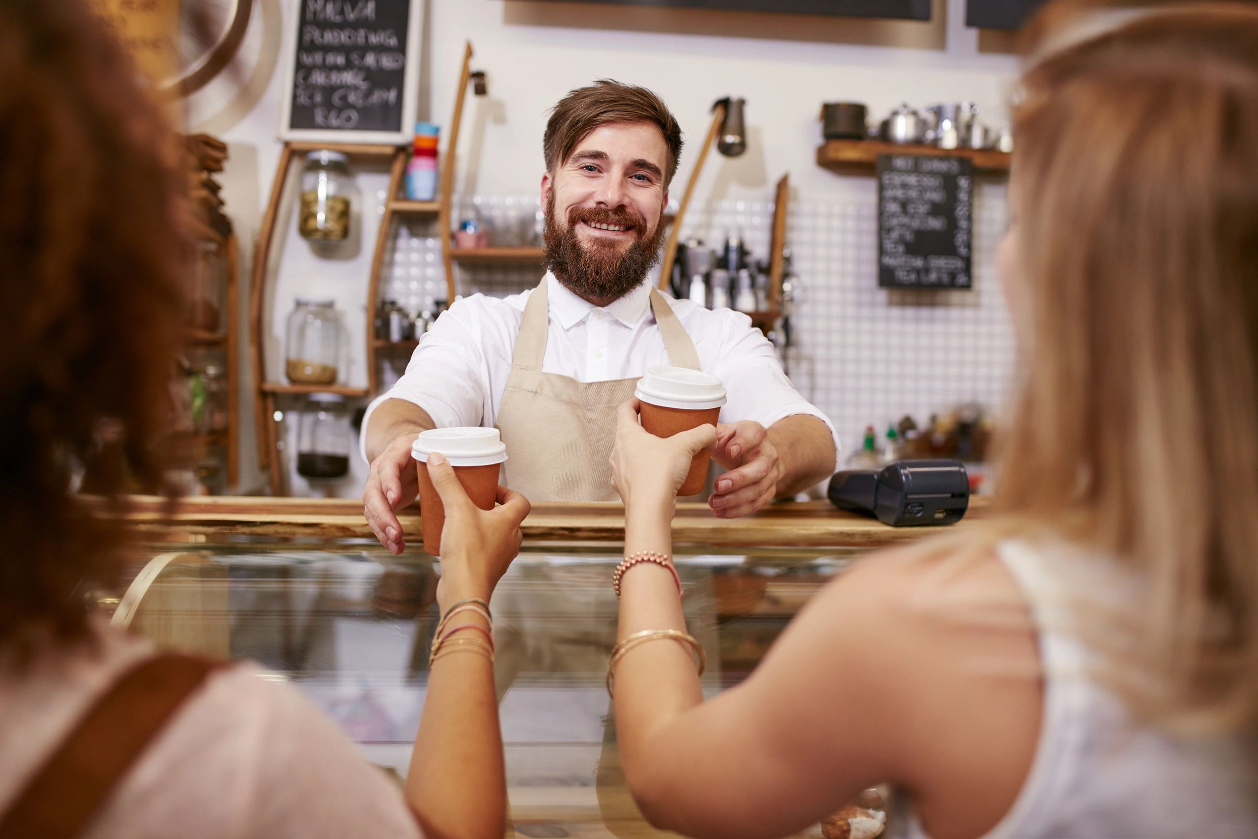 Barista serving coffee to guests at an event counter